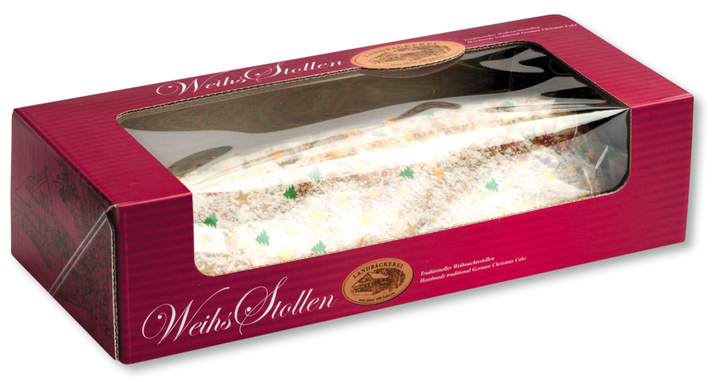 Ein Weihnachtsstollen in einem rot bedruckten Karton, den man durch das Sichtfenster sehen kann.