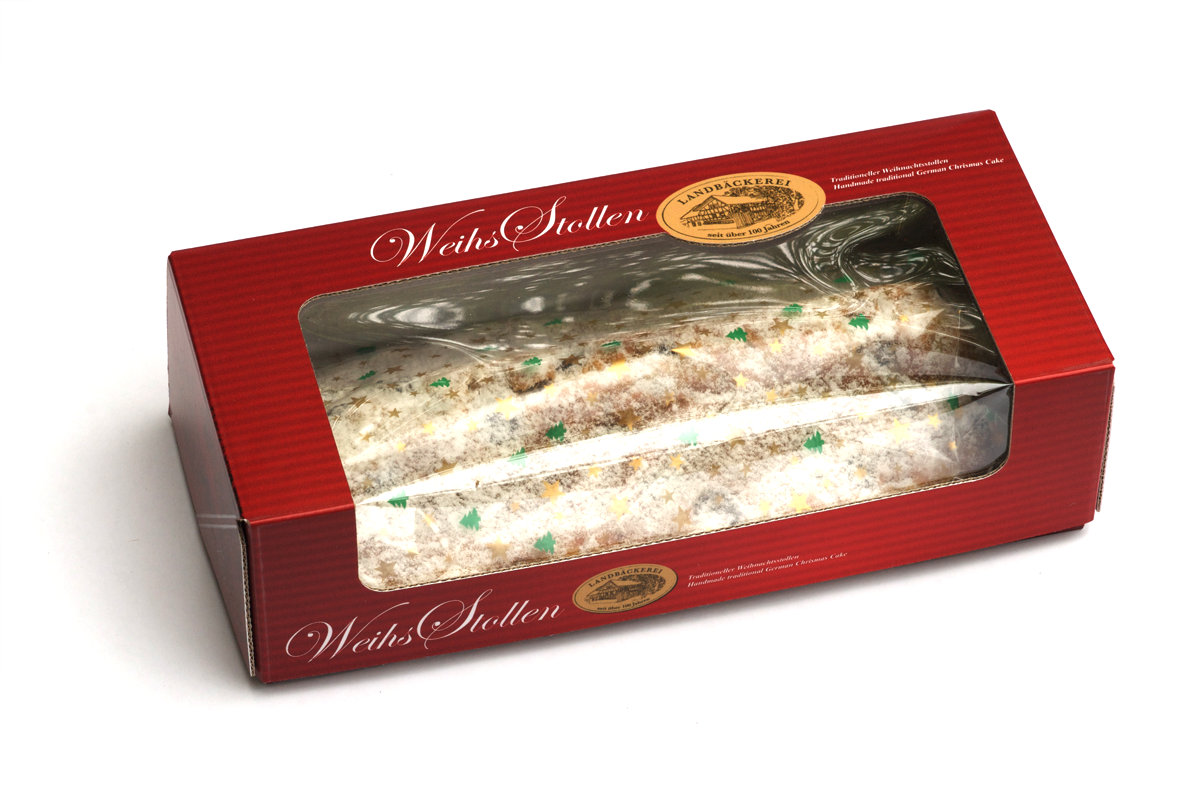 Geschlossener roter und mit dem Logo bedruckter Karton mit Sichtfenster, durch das man den in Klarsicht verpackten Weihs-Stollen sehen kann.