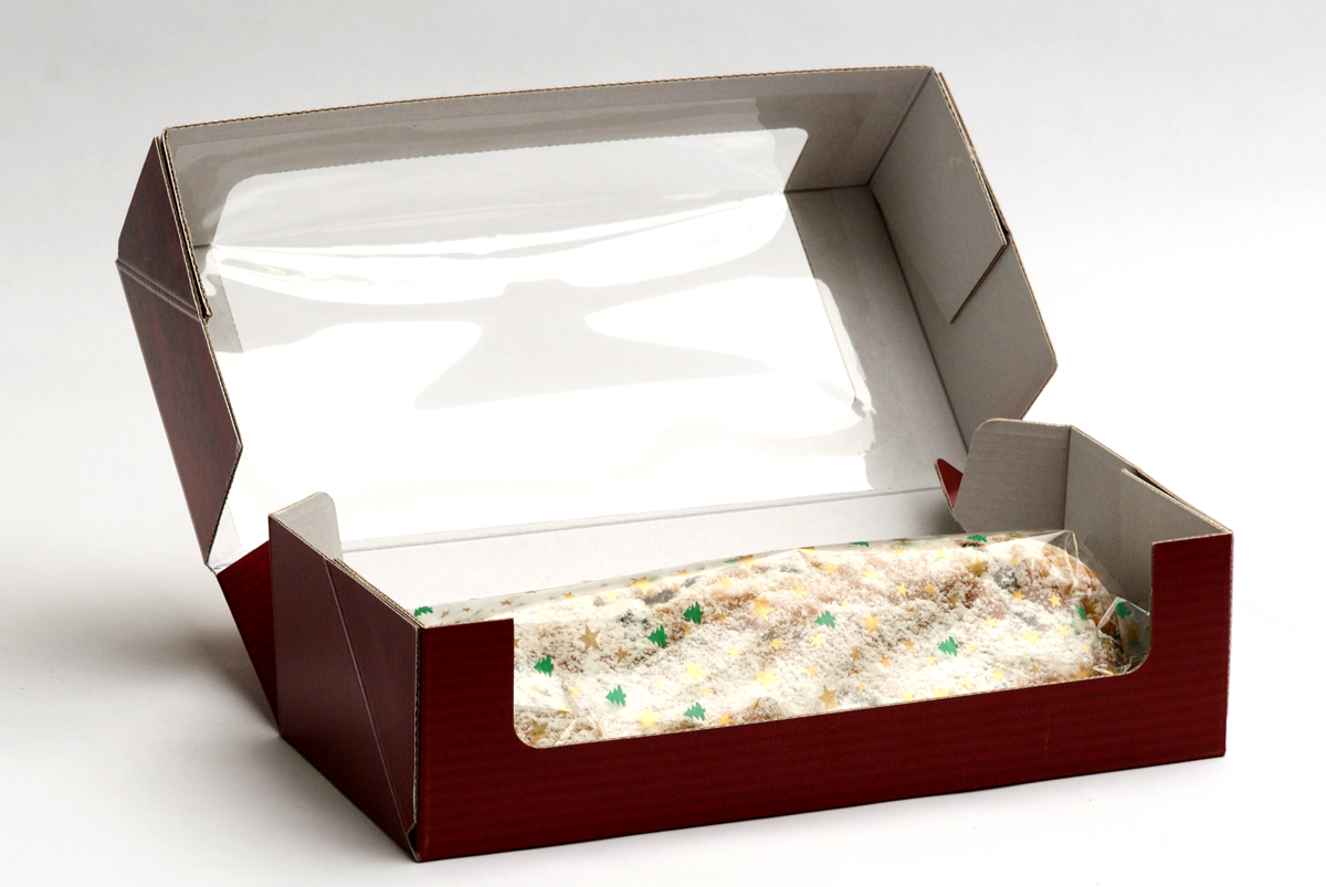 Weit geöffneter Karton in dem der in Klarsichtfolie verpackte Weihs-Stollen liegt.